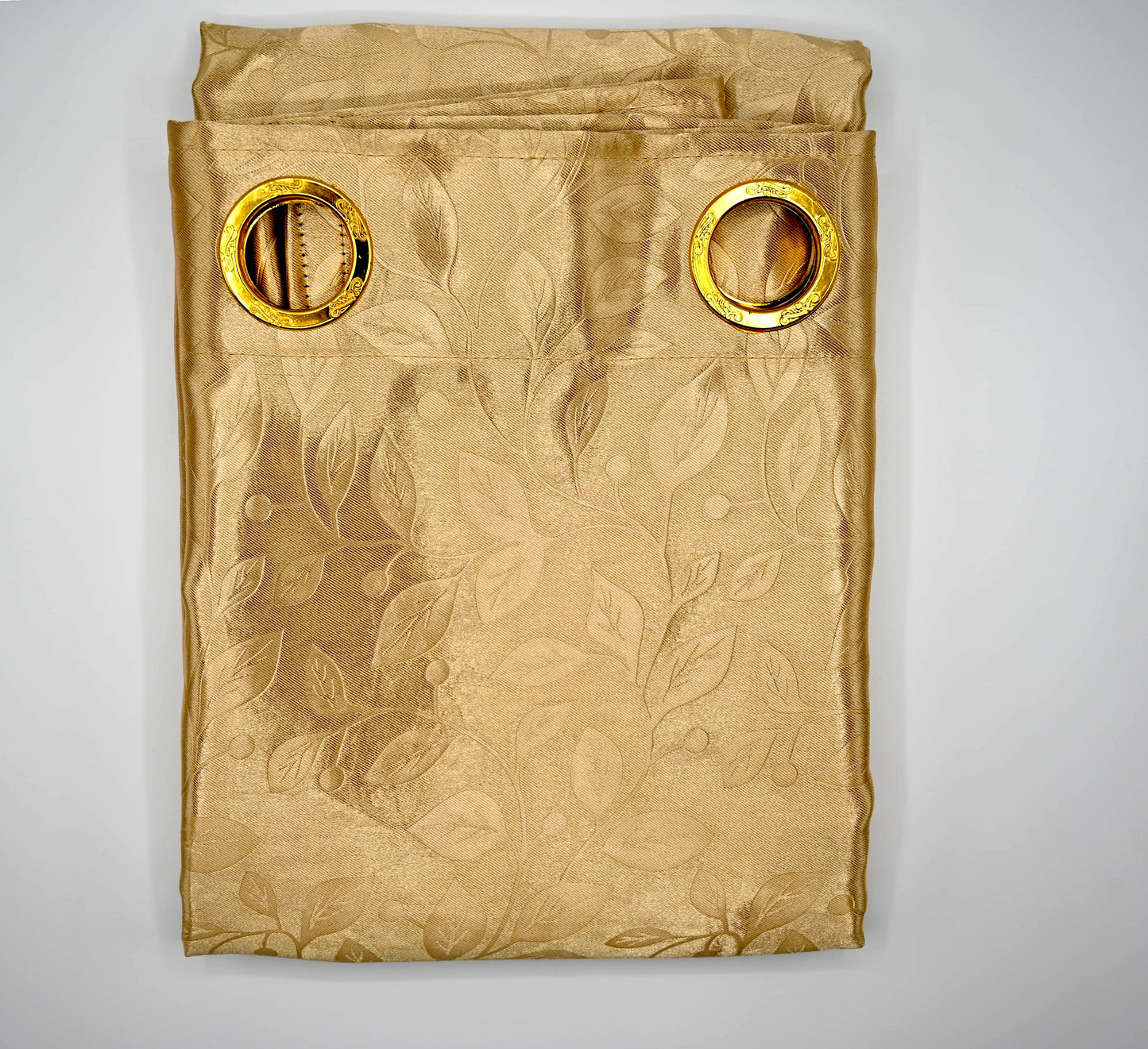 Gold curtain with floral pattern and gold rings on a white background