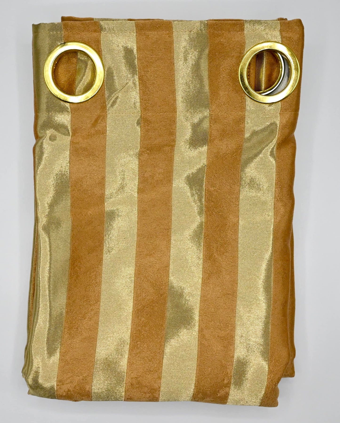 Folded fabric with gold and bronze stripes and gold rings on a white background