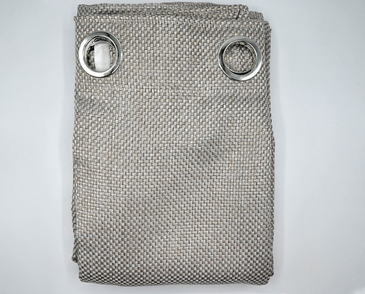 Folded textured fabric with metal rings on a light gray background