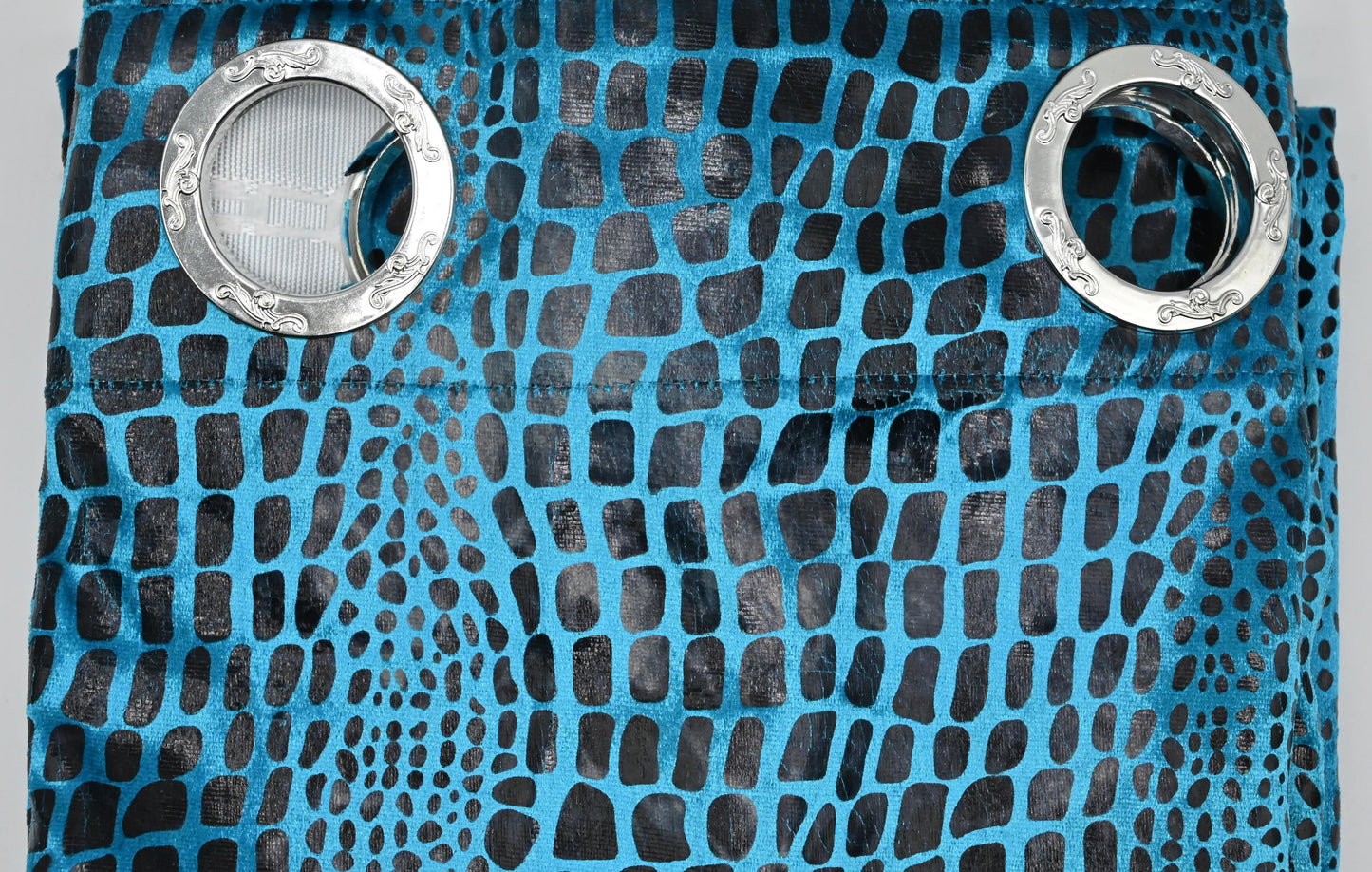Blue textured fabric with metal eyelets on a gray background