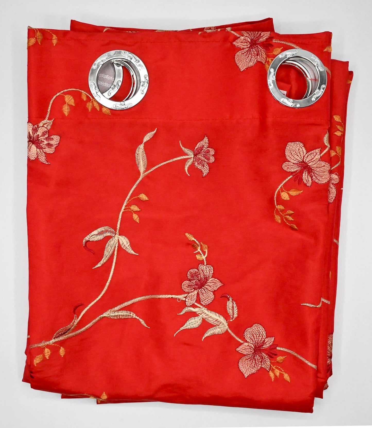 Red floral curtain with silver rings on a white background