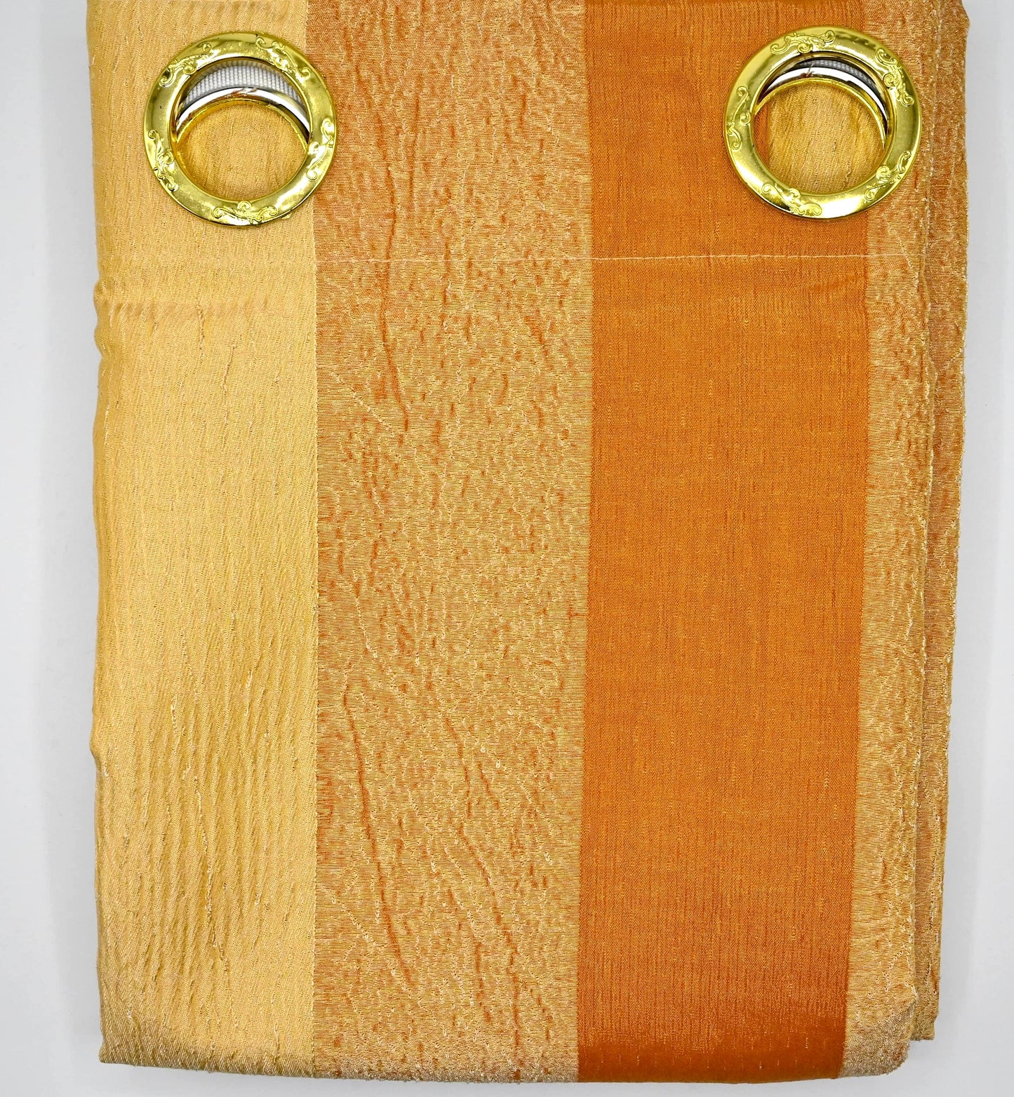 Folded fabric with gold eyelets on a white background
