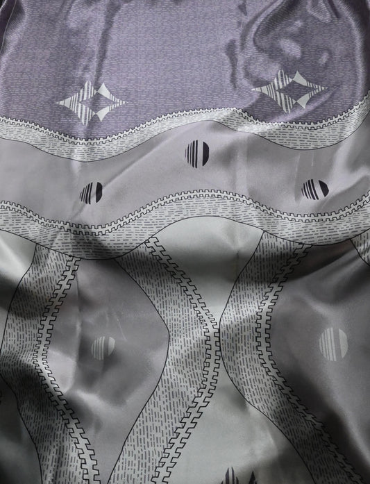 Close-up of a textured fabric with geometric patterns in gray and black.