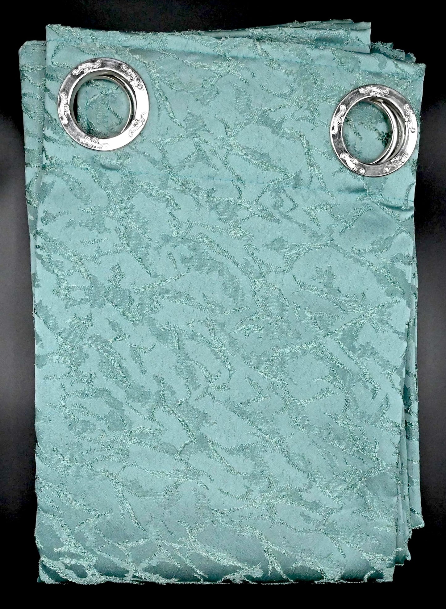 Seafoam vine coloured curtain with silver grommets on a black background