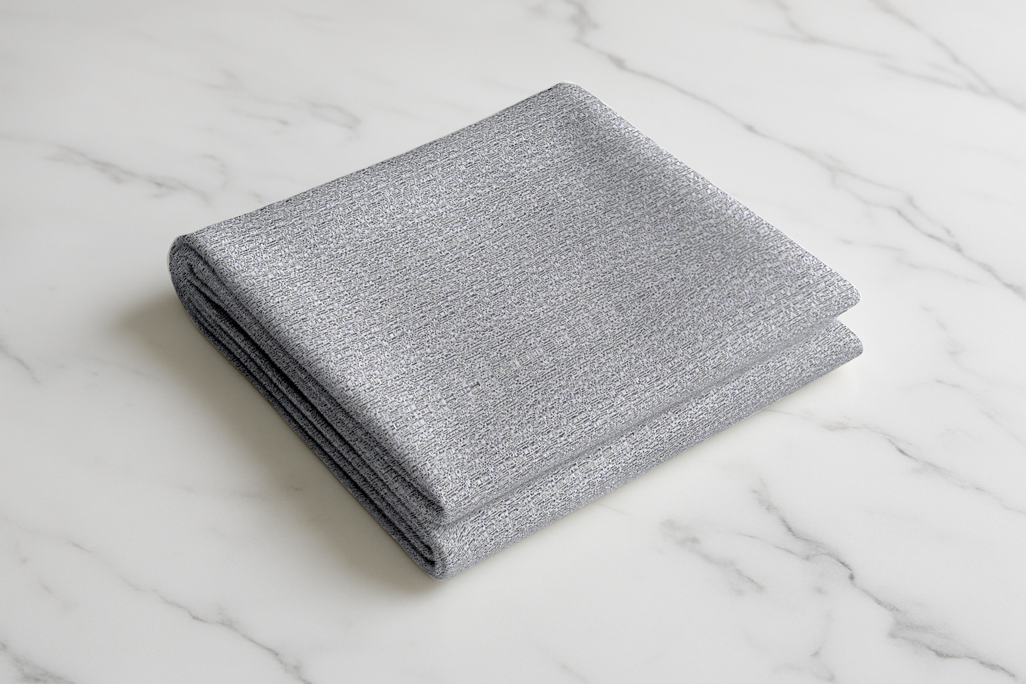 Folded silver-grey curtain fabric with a soft woven texture, displayed on a smooth surface, ideal for both modern and classic home styles