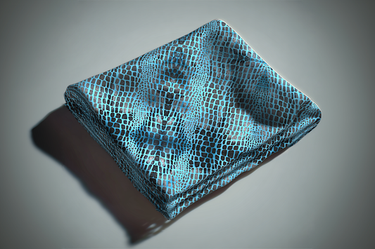 Blue and black pebble print curtain fabric with reptile scale pattern folded on white surface