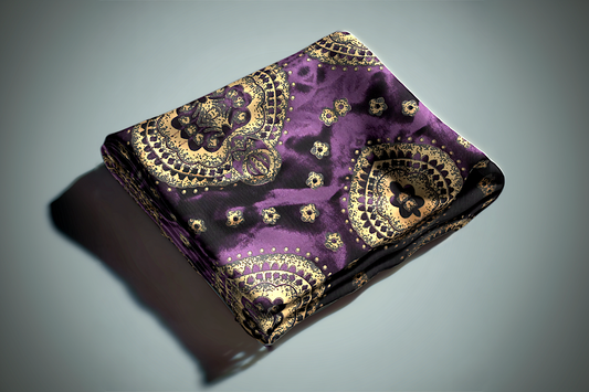 Purple and gold paisley curtain fabric with ornate medallion pattern and metallic accents folded on surface