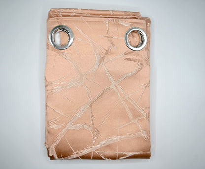 Folded beige curtain with metallic leaf pattern and silver grommets on a light gray background