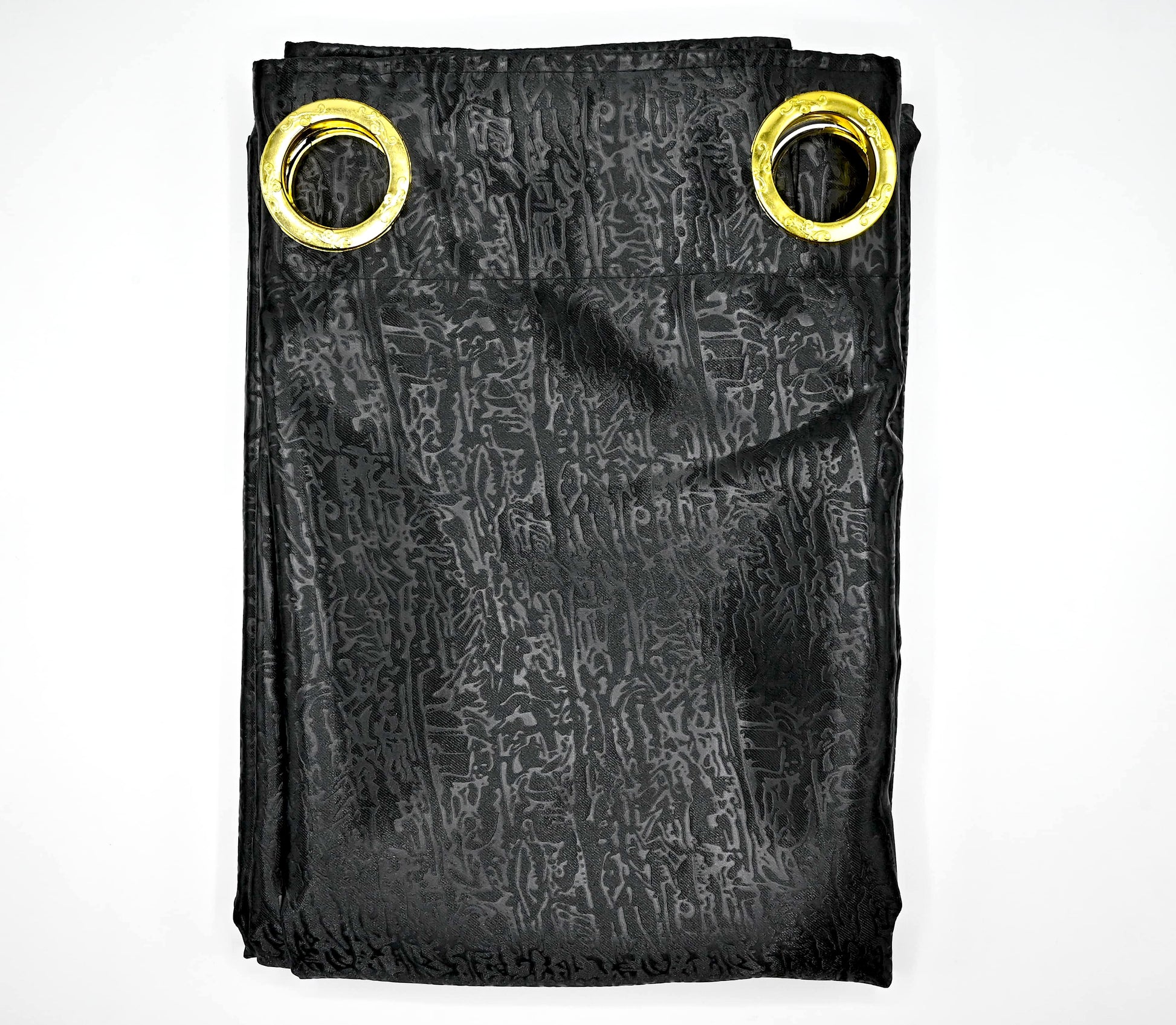 Black patterned fabric with gold grommets on a white background