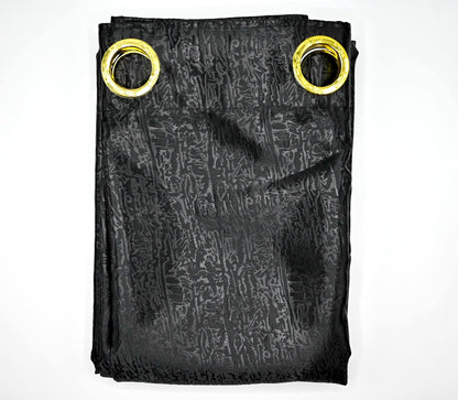 Black patterned fabric with gold grommets on a white background