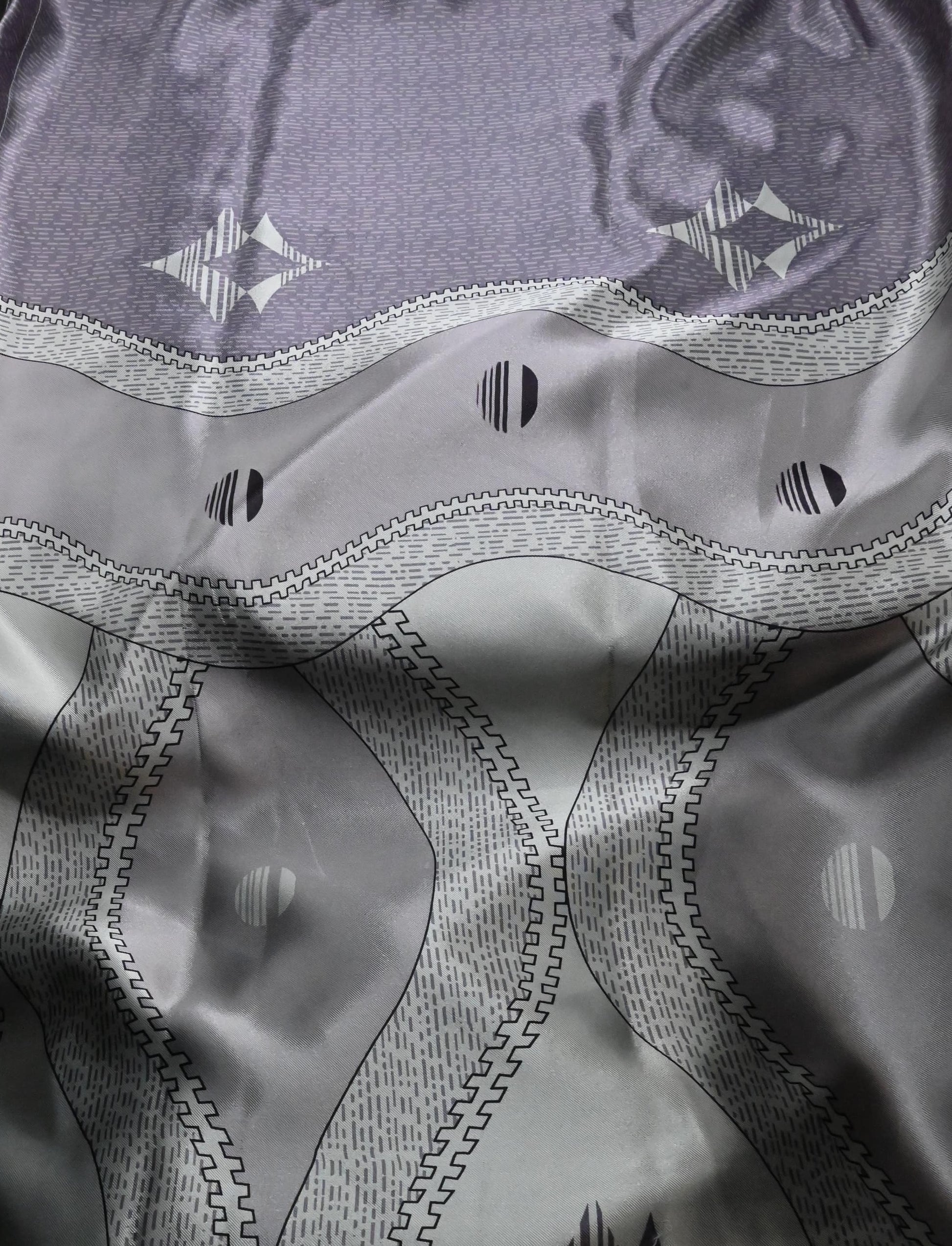 Close-up of a textured fabric with geometric patterns in gray and black.