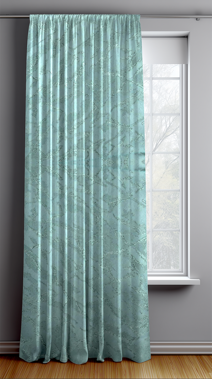 Seafoam vine curtain hanging in front of a window with a white frame on a gray wall.