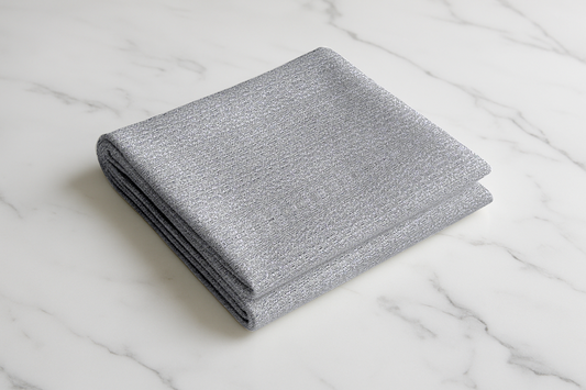 Folded silver-grey curtain fabric with a soft woven texture, displayed on a smooth surface, ideal for both modern and classic home styles