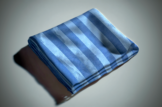 Blue striped curtain fabric folded on white surface showing alternating light and dark blue stripes